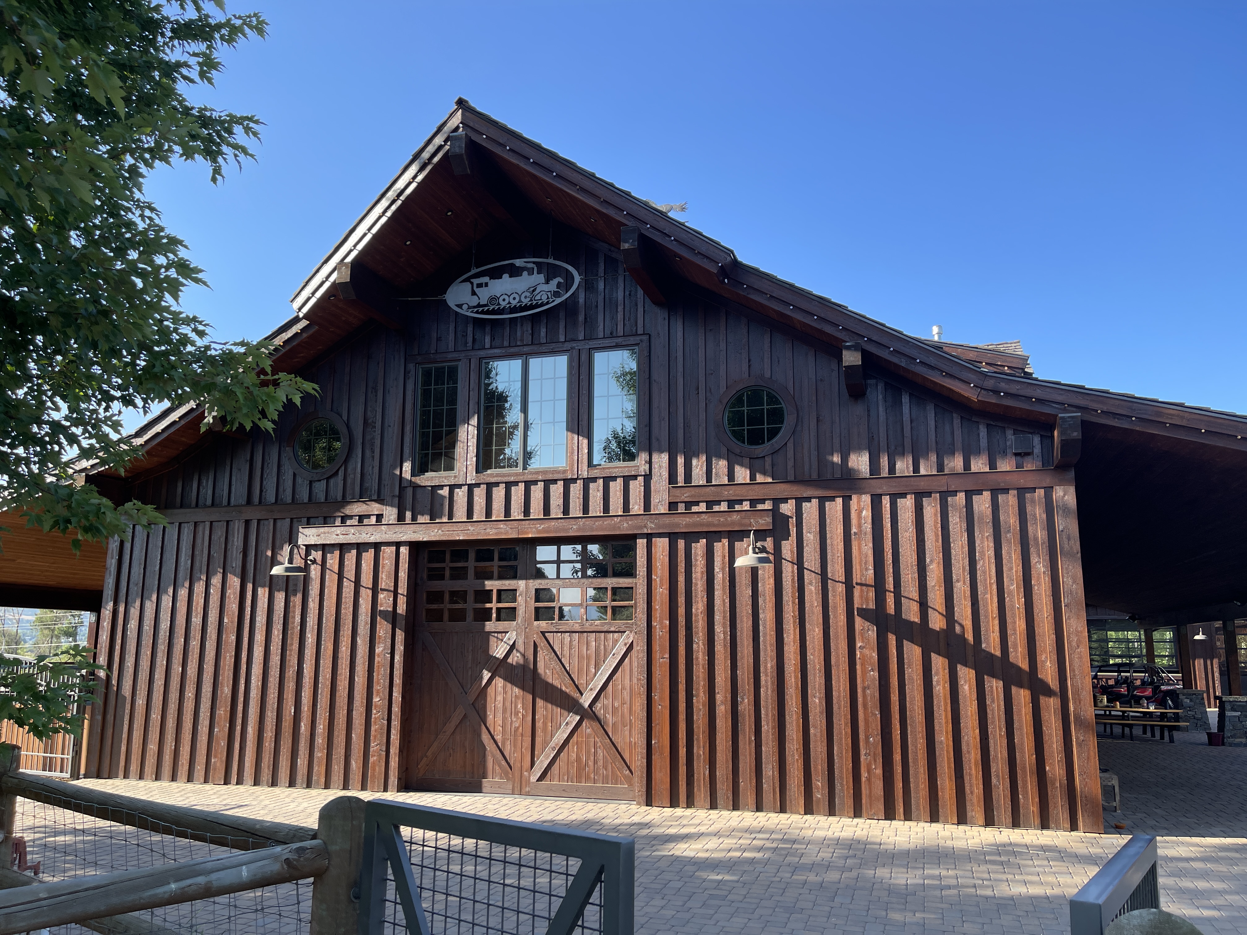 Dark-stained barn with X-pattern doors and round windows — Summit County, Utah