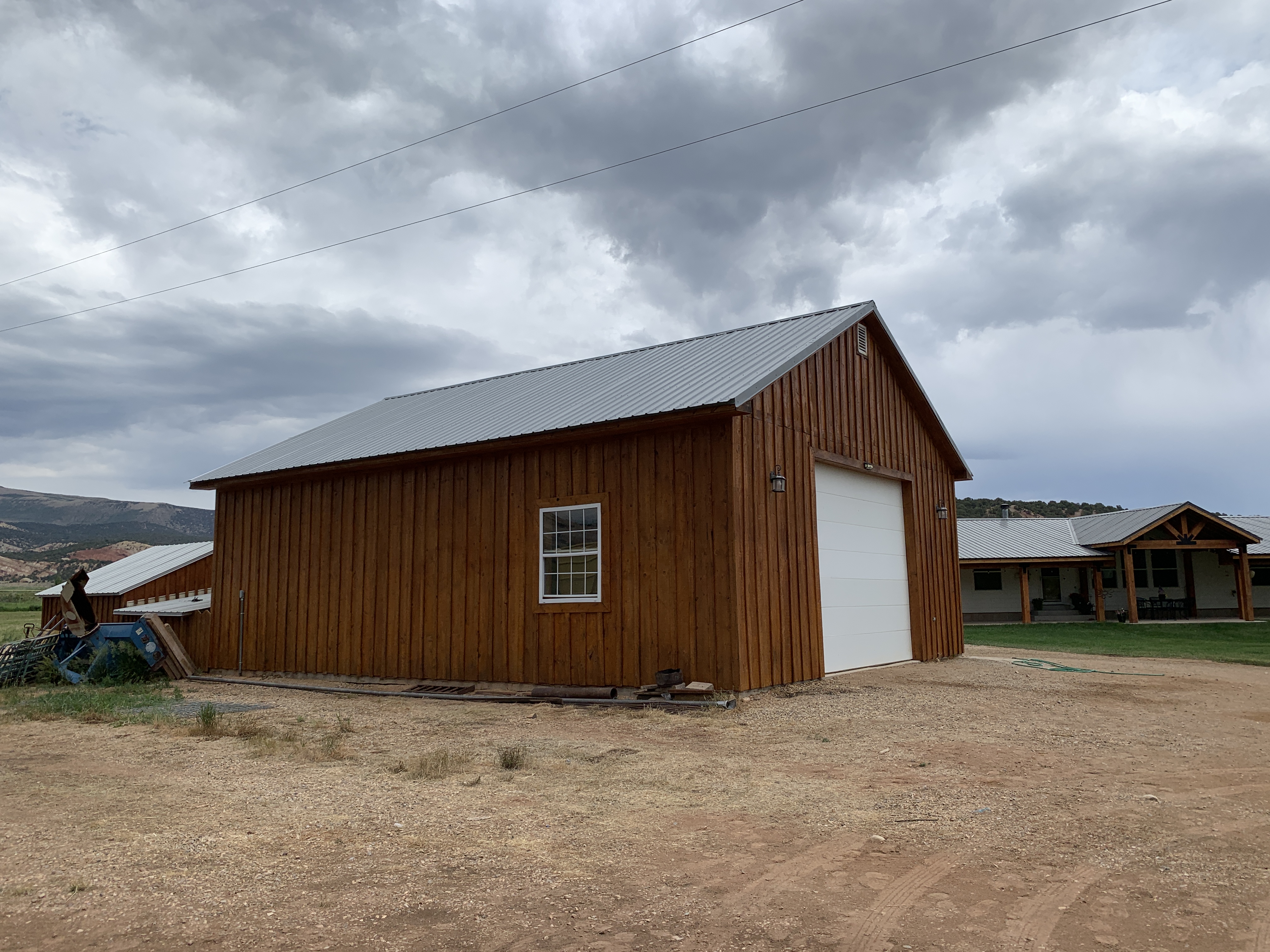 Wood barn with warm brown stain and white garage door — Summit County, Utah