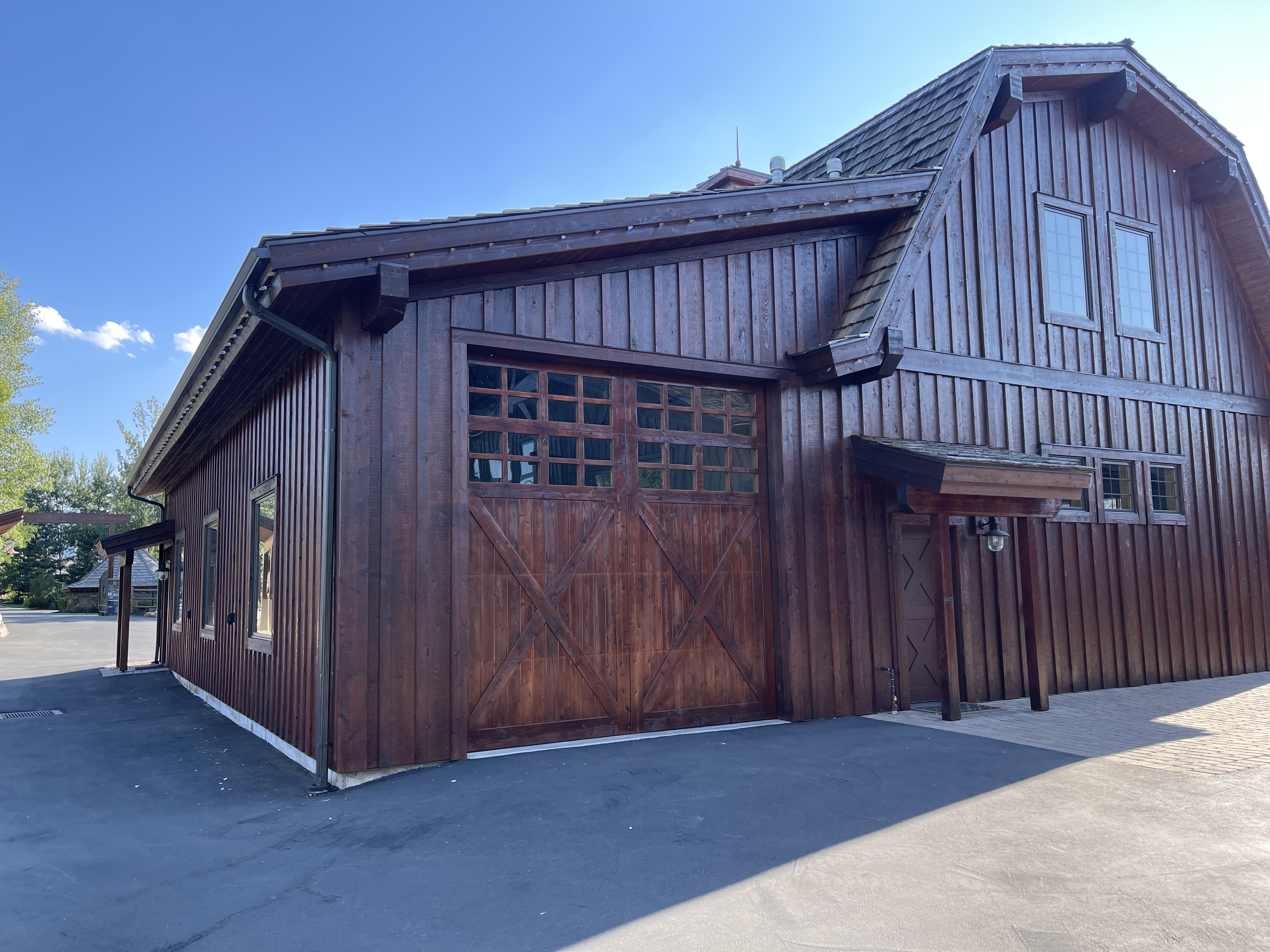 Large carriage house with dark walnut stain and X-pattern barn doors — Summit County, Utah