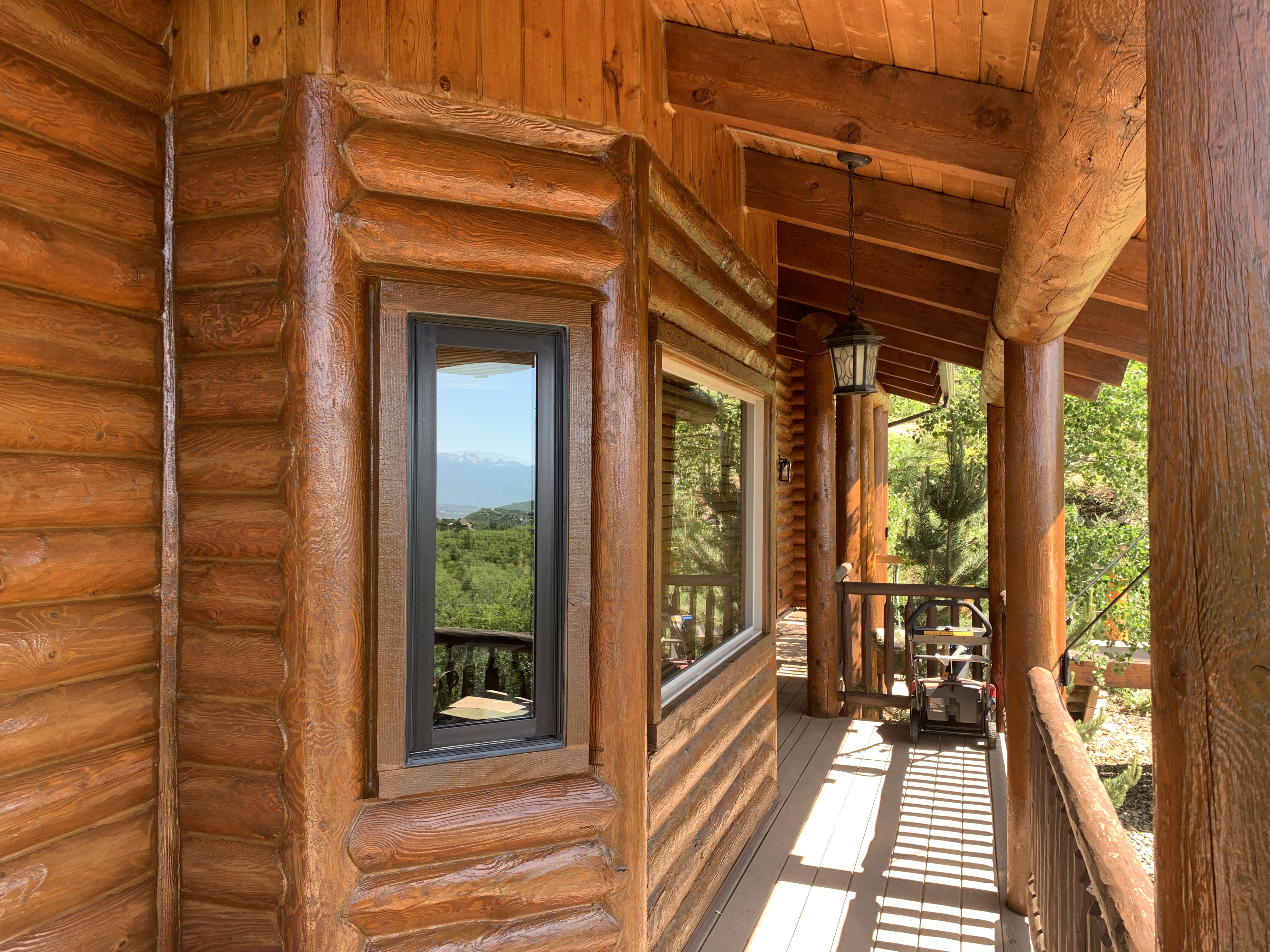 Warm stained timber porch entry with wood posts and stone accents — Summit County, Utah