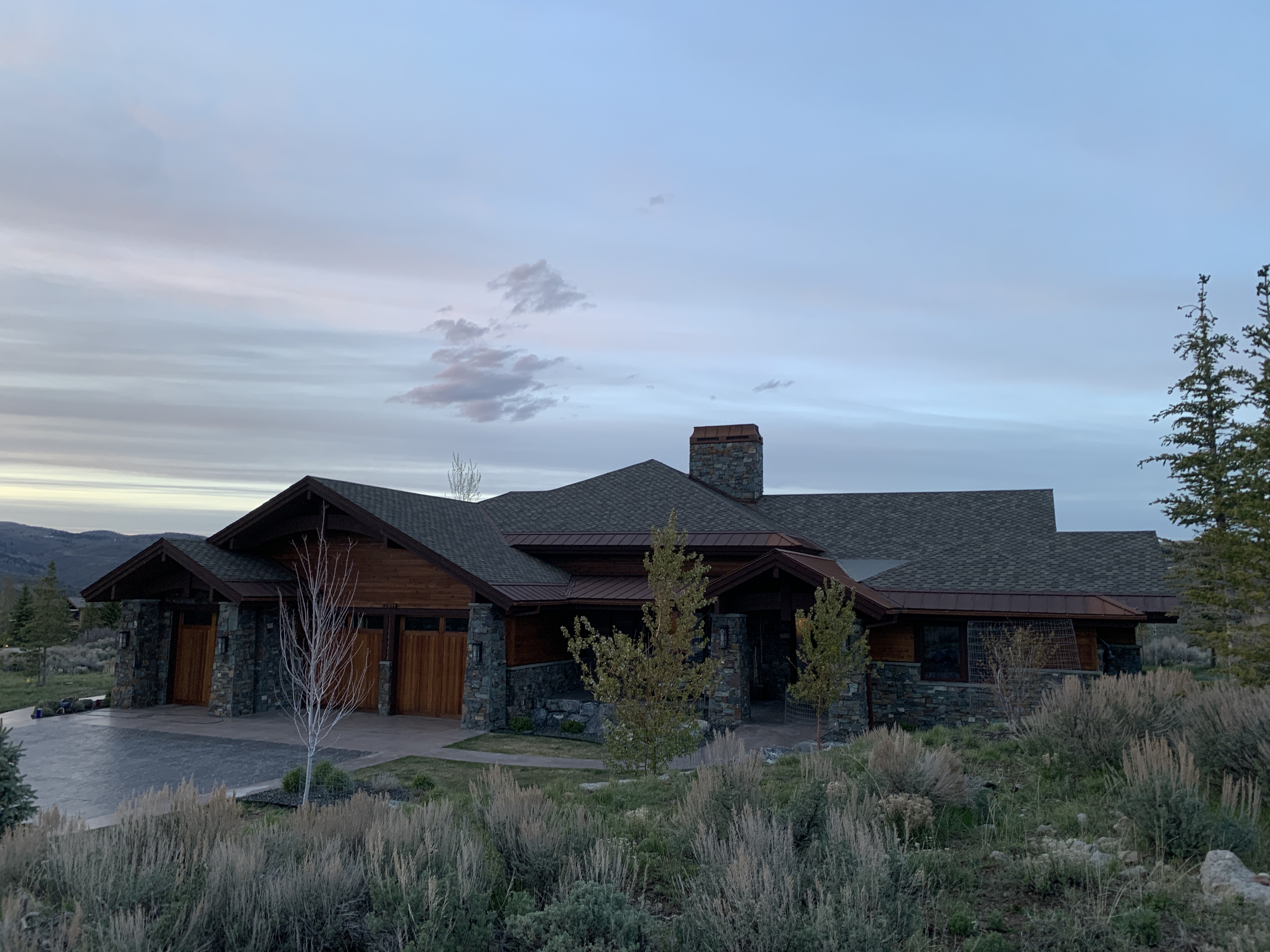 Luxury mountain estate with stone and cedar wood exterior at dusk — Summit County, Utah